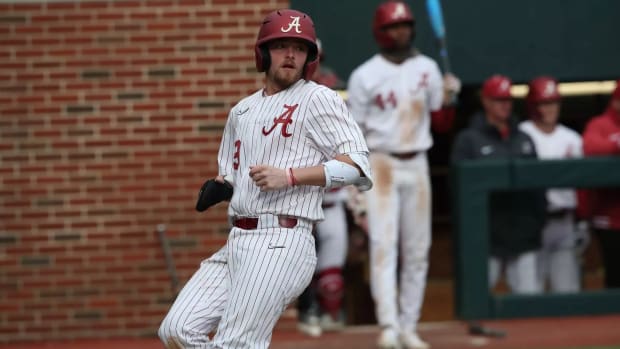 Alabama catcher Mac Guscette (9) scores a run while TJ McCants (44) looks on.